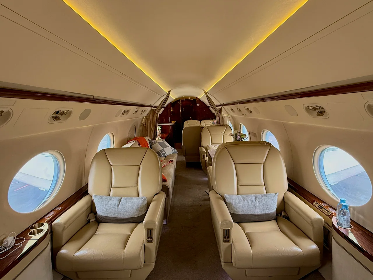 Spacious private jet cabin with cream leather seating